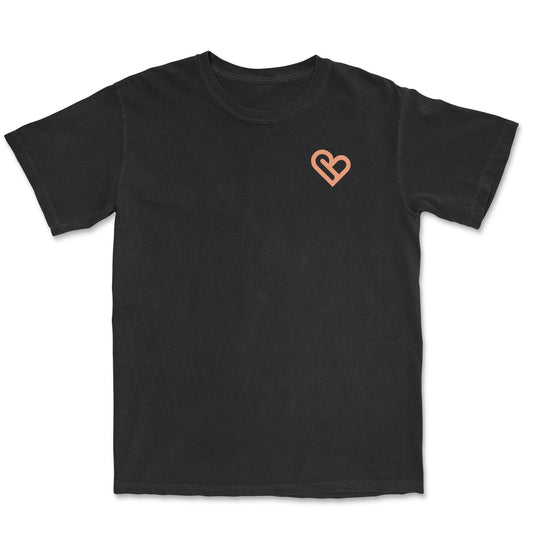 Black t-shirt featuring a peach-colored PSTVE Brand heart logo on the left chest.