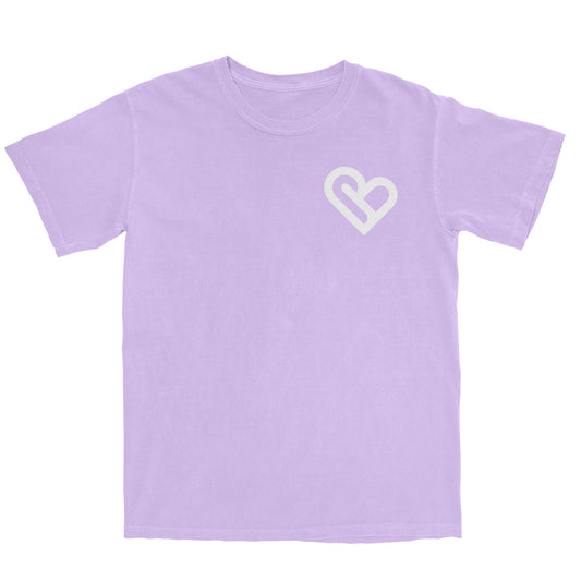 A light purple t-shirt with a white PSTVE (Positive) Brand logo on the left chest is displayed against a white background. The t-shirt has short sleeves and a round neckline.