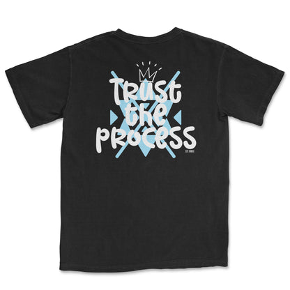 Black t-shirt with white "Trust the Process" graphic featuring a crown and light blue geometric shapes - PSTVE Brand